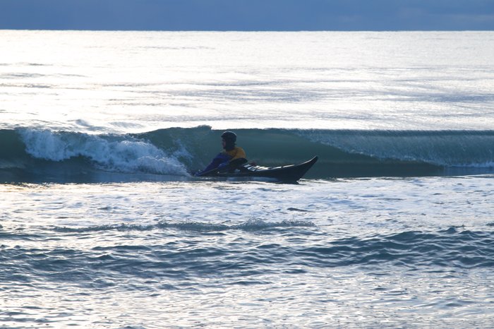 Sea kayak surfing.