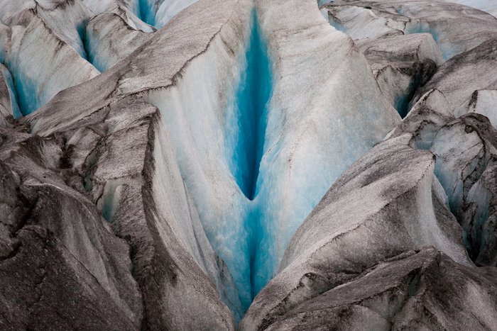 A deep shade of blue can be seen from the ice within this crevice