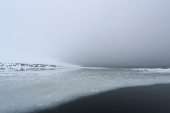 Above-freezing temperatures leaves thin sea-ice seeming to bleed into open water.