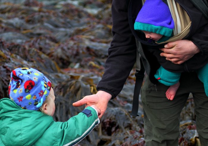 Both children look on at a crab Hig found