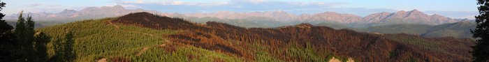 Fire spread up from the valley below, blackening forest and painting its edges red.