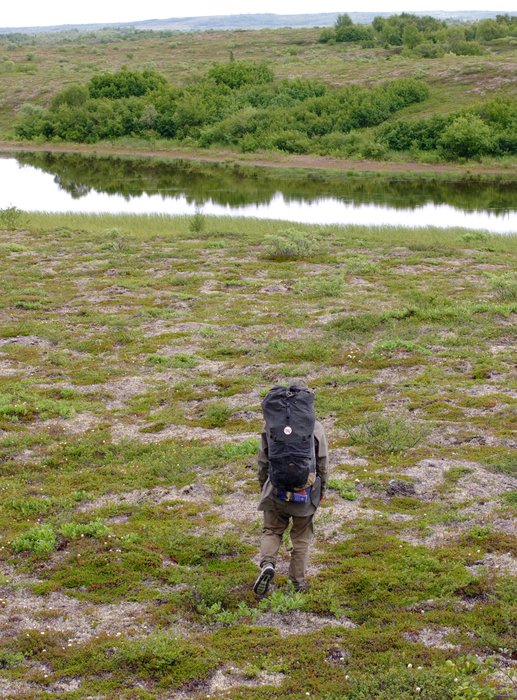 Erin walking across the tundra, with a "stop Pebble Mine" button on her backpack. 