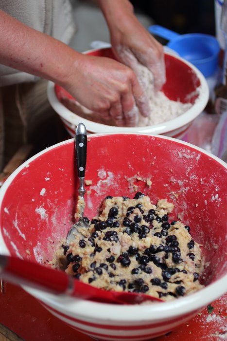 Mixing blueberry muffins and currant scones for guests