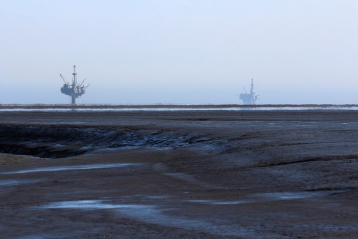 Oil rigs in the distance from the Trading Bay mudflats