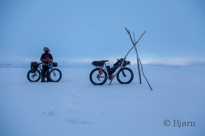 Riding through thick ice fog can be both beautiful and haunting. As the fog lifts and reveals daylight, Bjørn and Kim pause to appreciate the frozen dawn. 