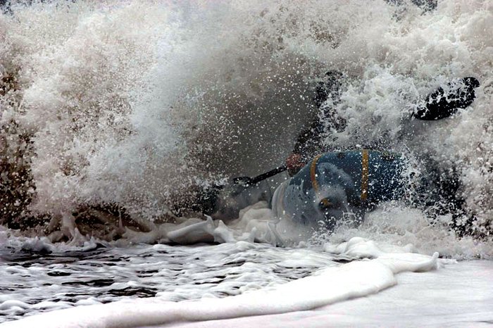 Hig surfs out of a breaking wave at the mouth of the Queets River in Washington