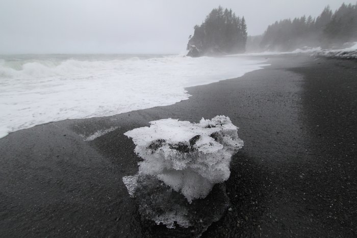 A chunk of icy snow calved to the beach, washed by storm waves.