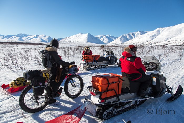 Two snowmachiners on their way to Nome pause to swap trail stories.