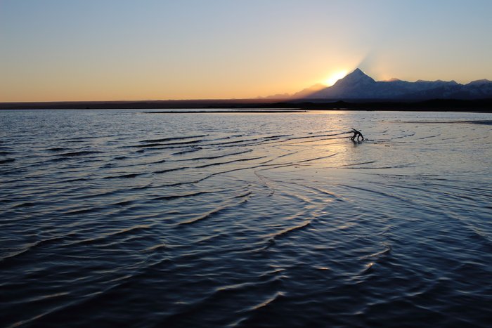 The sun drops behind Mt. St. Elias above the shore of Malaspina Lake.