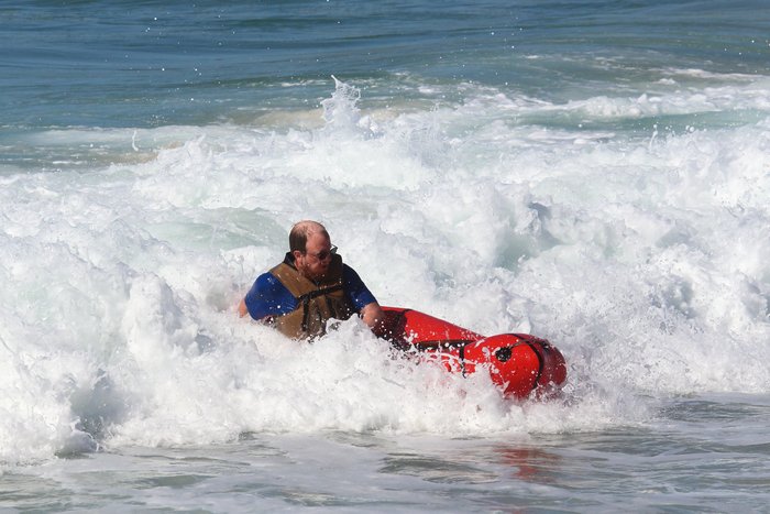 Hig is carried in to shore with a wave.