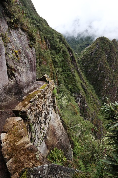This unusual section of trail originally built in Inca times has a tread where the outer half of the tread is set stones, while the inner half is carved directly into the granite cliff.